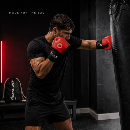 Boxer training on a punch bag wearing red and black SPLAY leather bag mitts